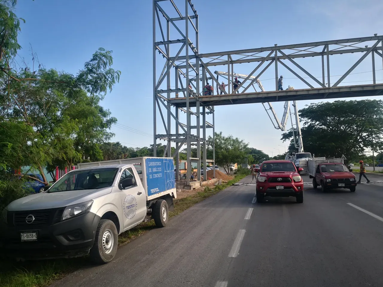 Obra de un puente peatonal con la unidad del laboratorio TESTCO estacionada junto a la vialidad